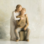 Willow Tree You and Me, 7”h hand-painted resin figure of couple; seated man, woman standing behind with arms around neck, both in neutral clothes, in front of taupe painting