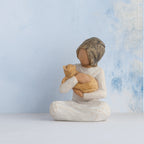 Willow Tree Kindness (girl), 3" hand-painted resin figure in cream dress, darker skin and hair, sitting and holding yellow cat, in front of pale blue painting