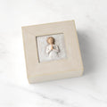 Cream square wood box with hinged lid, carving on lid of female in cream dress with hands in prayer position, surrounded by leaves and vines