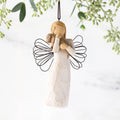 Female angel figure in cream dress with wire wings, holding brown dog in arms, ornament loop attached to head