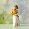 Willow Tree Good Cheer, 5.5" hand-painted standing resin figure in cream dress, holding bouquet of yellow roses, in front of pastel painting