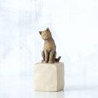 Golden cat figurine sitting on white rock
