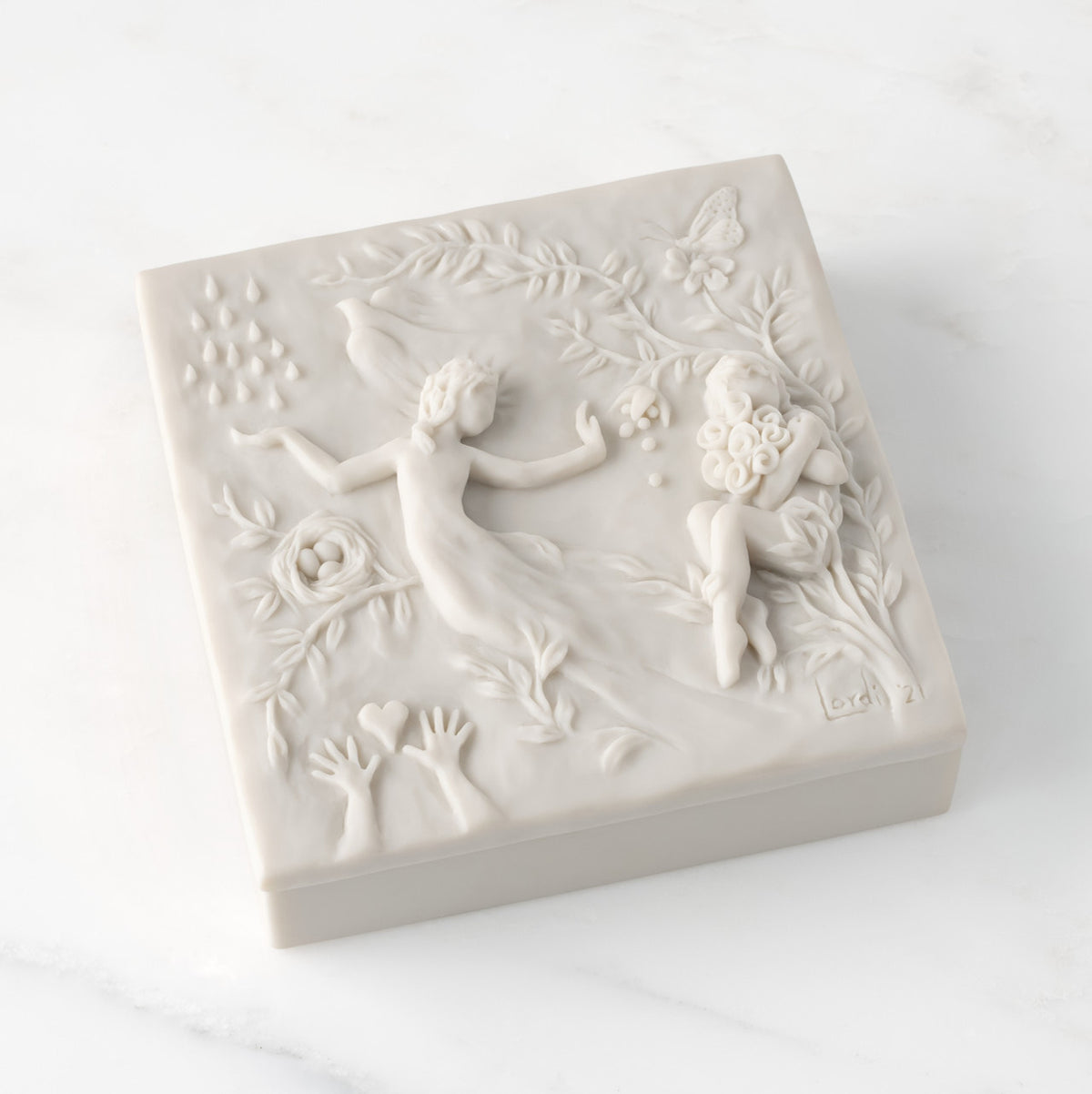 Closed white resin box; lid carved with figural and organic imagery