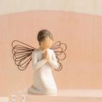 Willow Tree Angel of Prayer, 4"h hand-painted resin kneeling figure in cream dress, wire wings and hands in prayer position, in front of coral painting