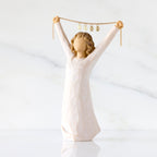Front view: figure in cream dress holding gold chain above her head with year 2025 on it