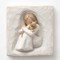 Close up of carved white square stone - in the middle is faceless young girl holding brown cat