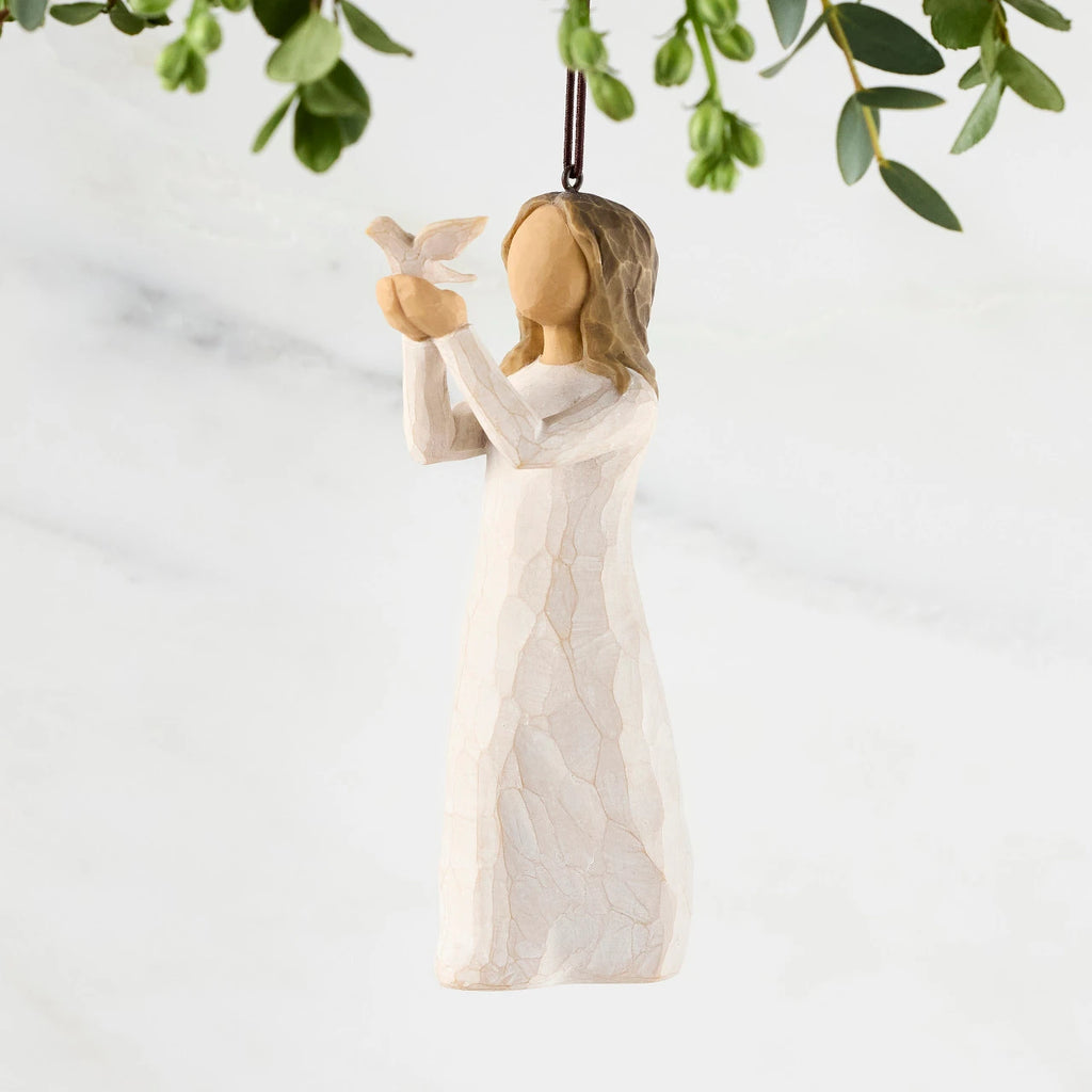 Figure in cream dress, holding white dove on extended arms. Hook and loop affixed to figure's head