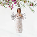 Front: Angel Ornament with wire wings, darker skin, arms crossed over gold heart, dress carved with symbols of remembrance