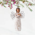 Front: Angel Ornament with wire wings, darker skin, arms crossed over gold heart, dress carved with symbols of remembrance