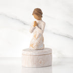 Cream oval resin box, 3-D figure in prayer pose atop lid, in cream dress carved with birds and flowers