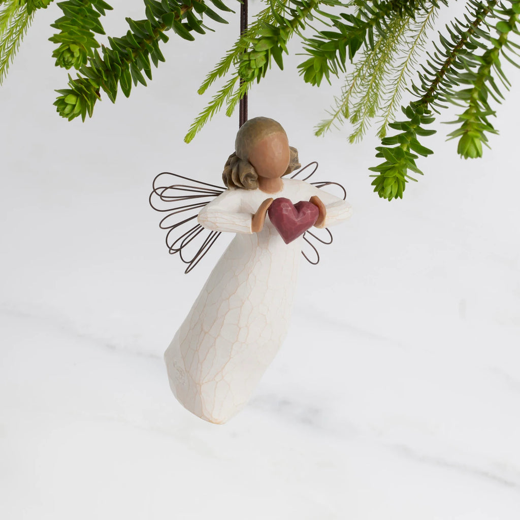 Front view: Darker-skin Angel with wire wings holding red heart. Hook and loop