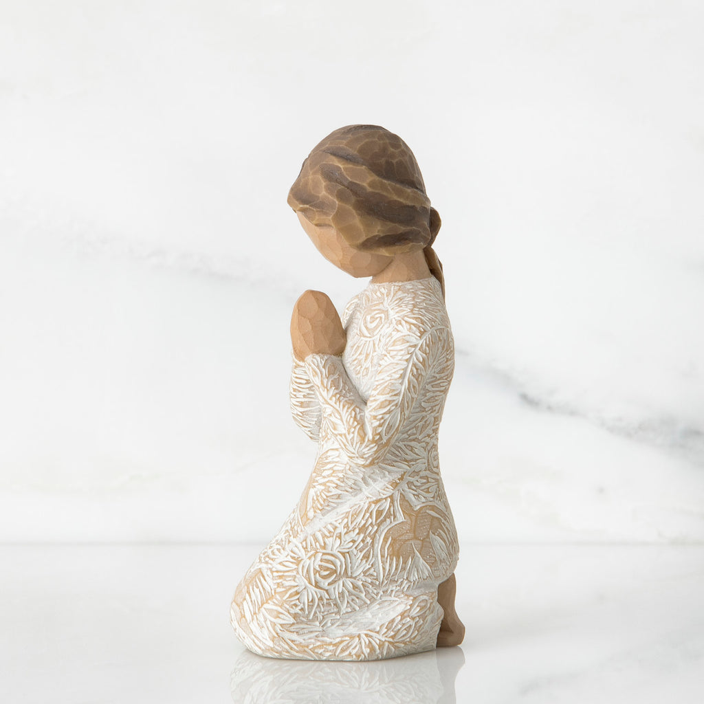 Small brunette girl figurine in white dress kneeling with hands folded - side view