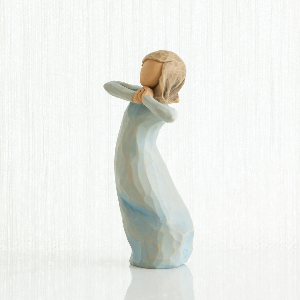 Small girl figurine in light blue dress standing with her hands up