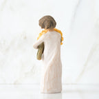 Back view of little girl with short brown hair holding a large bouquet of yellow roses