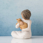 Small brunette girl figurine sitting wearing white dress holding golden cat figurine - blue background