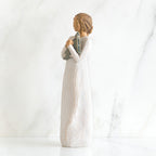Side view of brunette girl figurine in white dress holding triangle figurine
