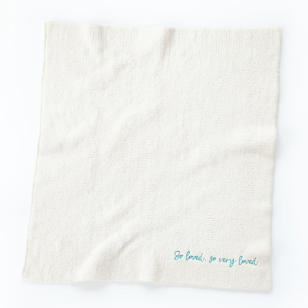 Overview of white towel with 'so loved, so very loved' in light blue in the right corner