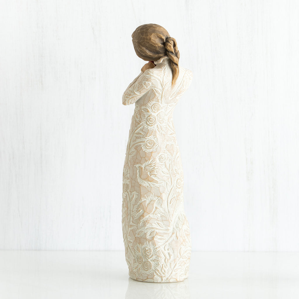 Side view of younger girl brunette figurine wearing white dress facing the other side