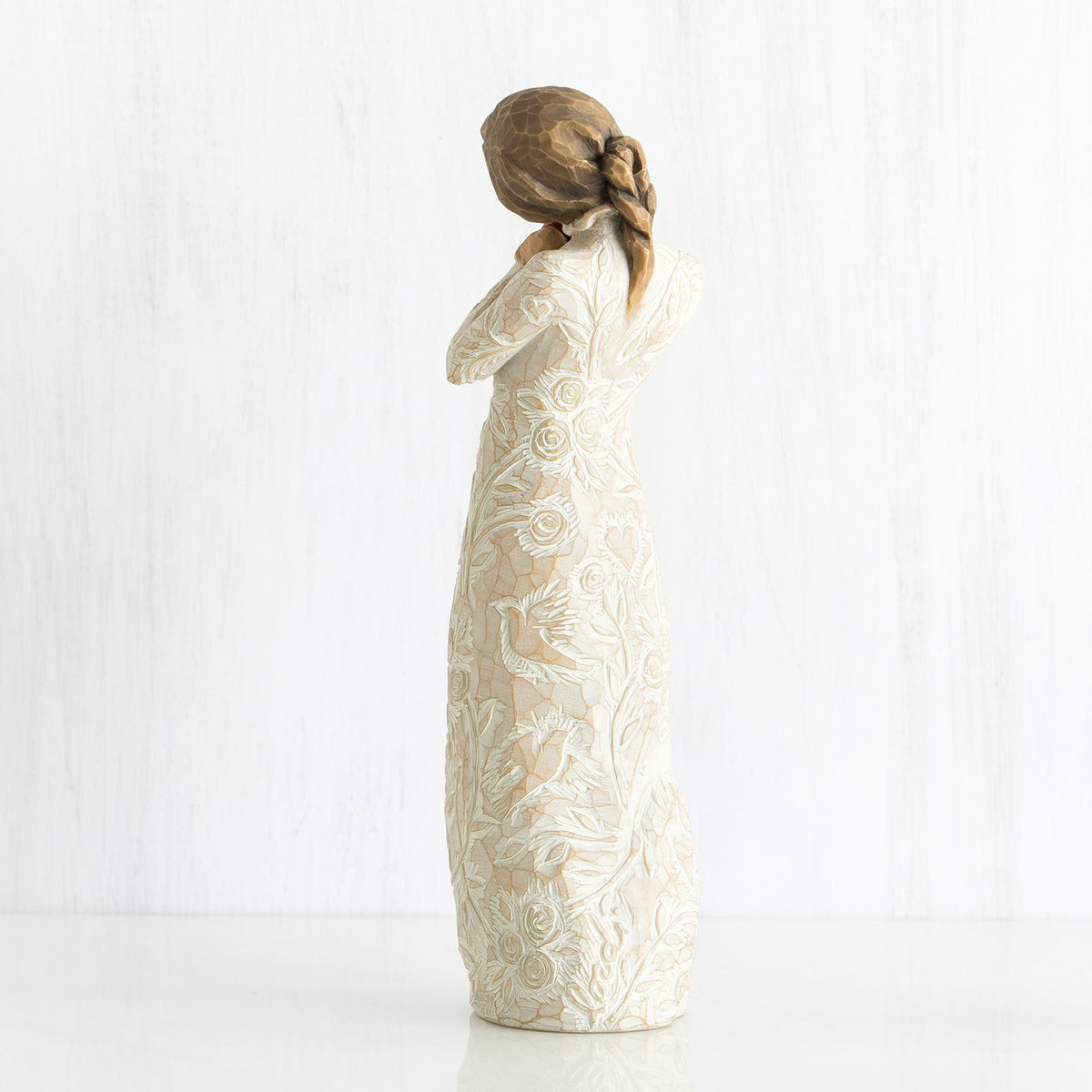 Side view of younger girl brunette figurine wearing white dress facing the other side