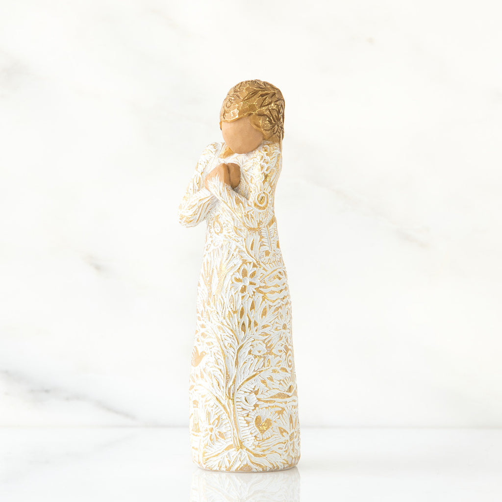 Gold haired woman in white/gold dress facing forward with arms to her chest