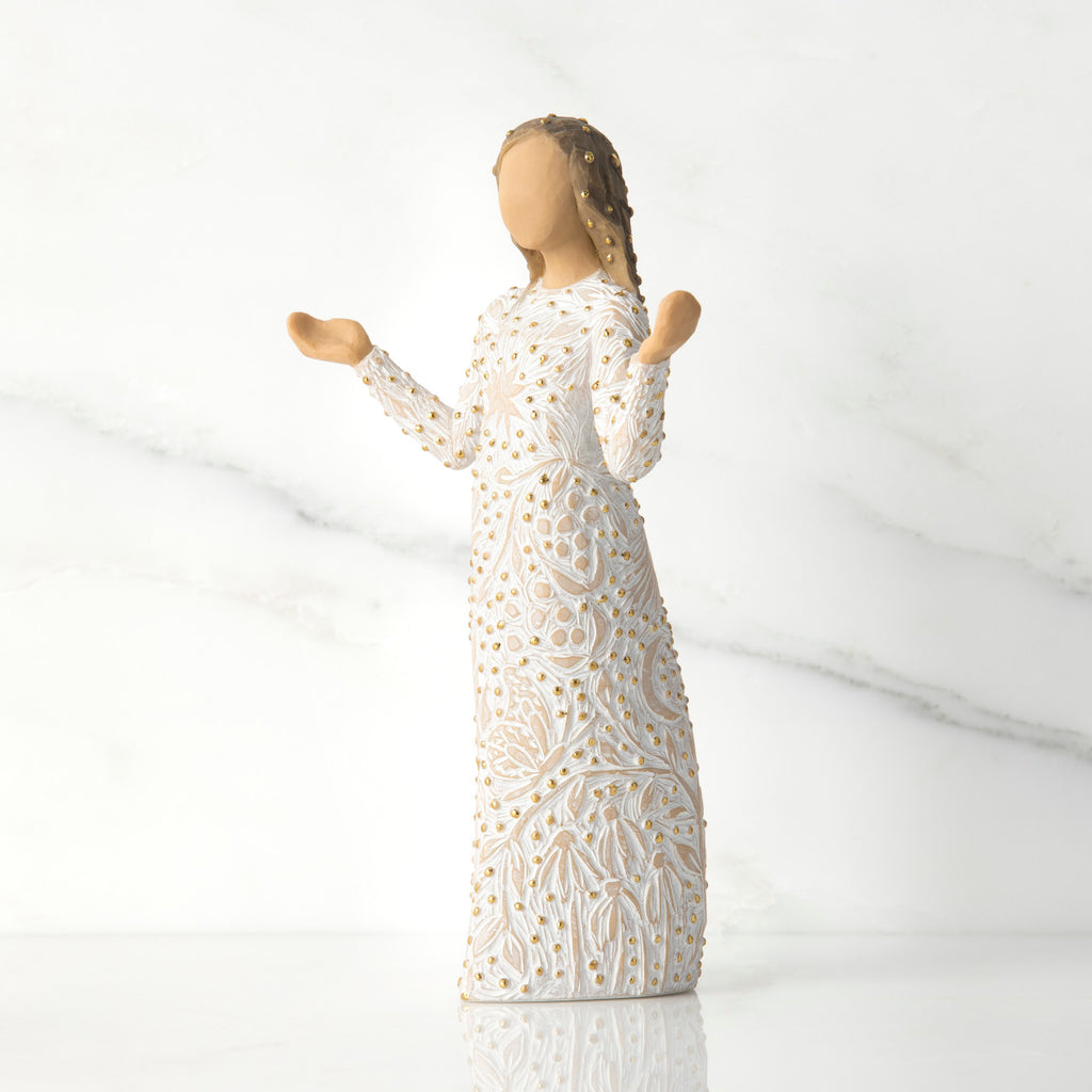 Side view of brunette girl figurine in white dress with gold dots holding her hands up