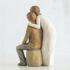 Back view - woman figurine in white dress hugging man figurine in brown shirt and blue jeans