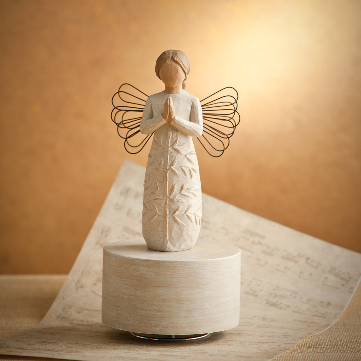 Willow Tree a tree, a prayer Musical, 7.5”h hand-painted resin angel figure in cream dress with wire wings, hands in prayer position, tree carving on dress, atop round, cream base containing musical element, lit in a warm glow