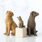 Set of two golden and grey dog figurines sitting in between grey cat figurine