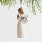 Side view female figure with wire wings in cream dress carved with a tree design, holding hands in prayer, ornament loop attached to head