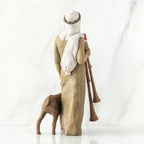 Back view of man figurine in tan dress with white turban - next to donkey figurine