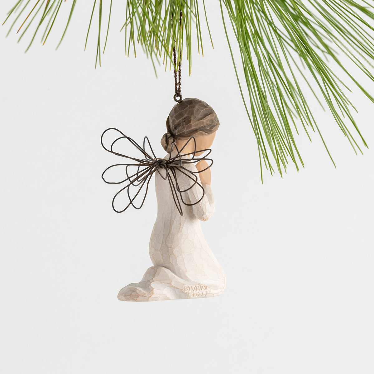 Side view figure of female angel in cream dress and wire wings, kneeling in prayer position, ornament loop on head
