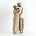Back view of man and woman figurines hugging one another