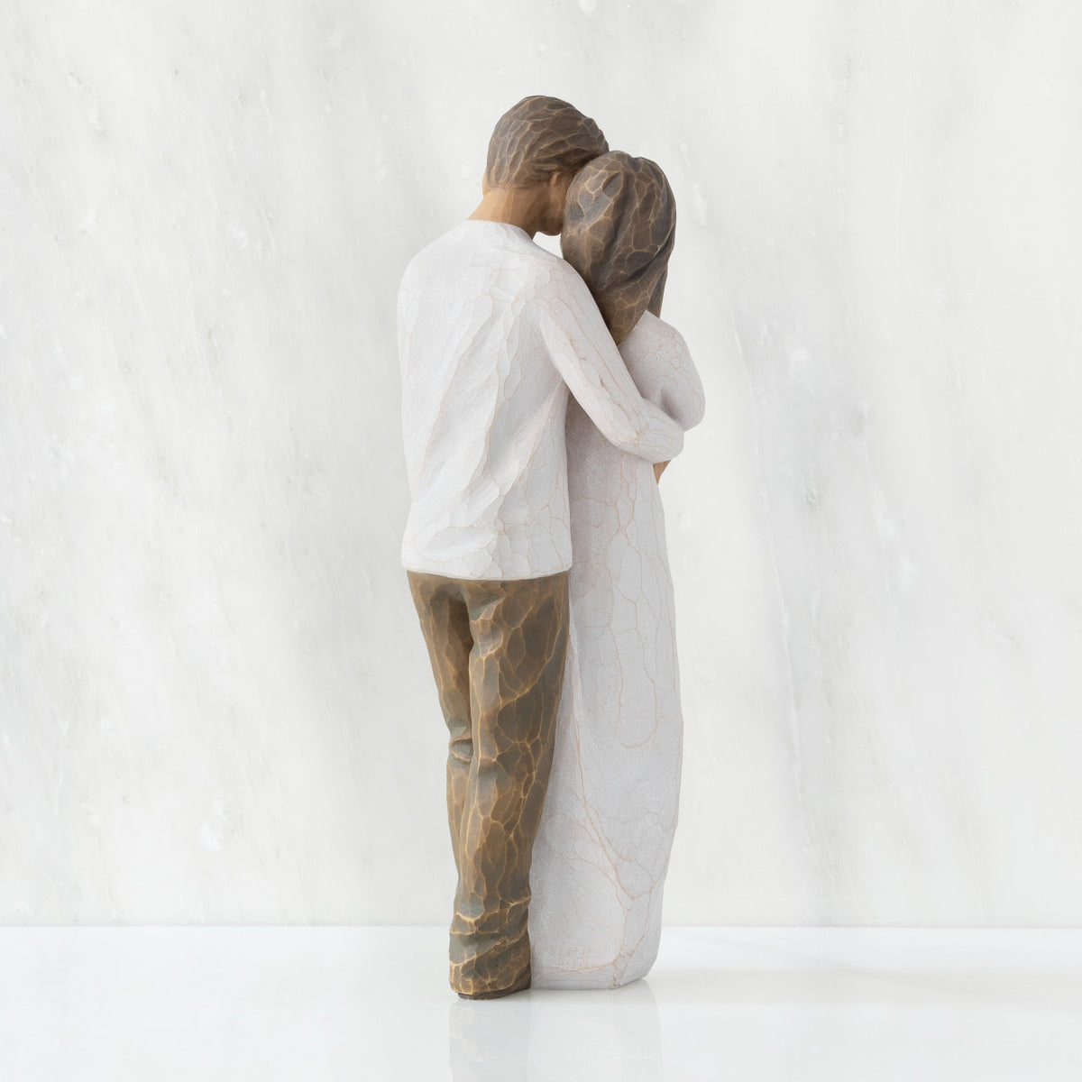 Back view of couple, standing with arms around each other. Woman and man have darker skin tones and hair color.