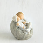 Close view of grey bean bag with two siblings hugging one another on it
