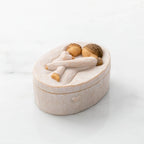 Willow Tree Tenderness Keepsake Box, 3.4" oval x 2.4" W x 1.5" D hand-painted resin box with removable lid off to one side, Lid has bas-relief carving of woman holding toddler, touching foreheads, inside of box has sentiment
