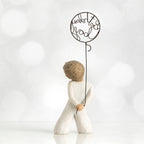 Back view of little boy with light brown hair holding a wire balloon behind his back. Text on balloon is wire