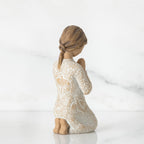 Back view of little brunette girl kneeling in white dress
