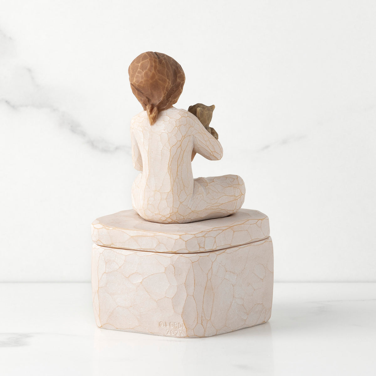 Back: cream square resin box with lid, 3-D figure of seated girl holding cat atop lid