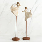 Set of two angel figurines in white dresses danging on wooden stands
