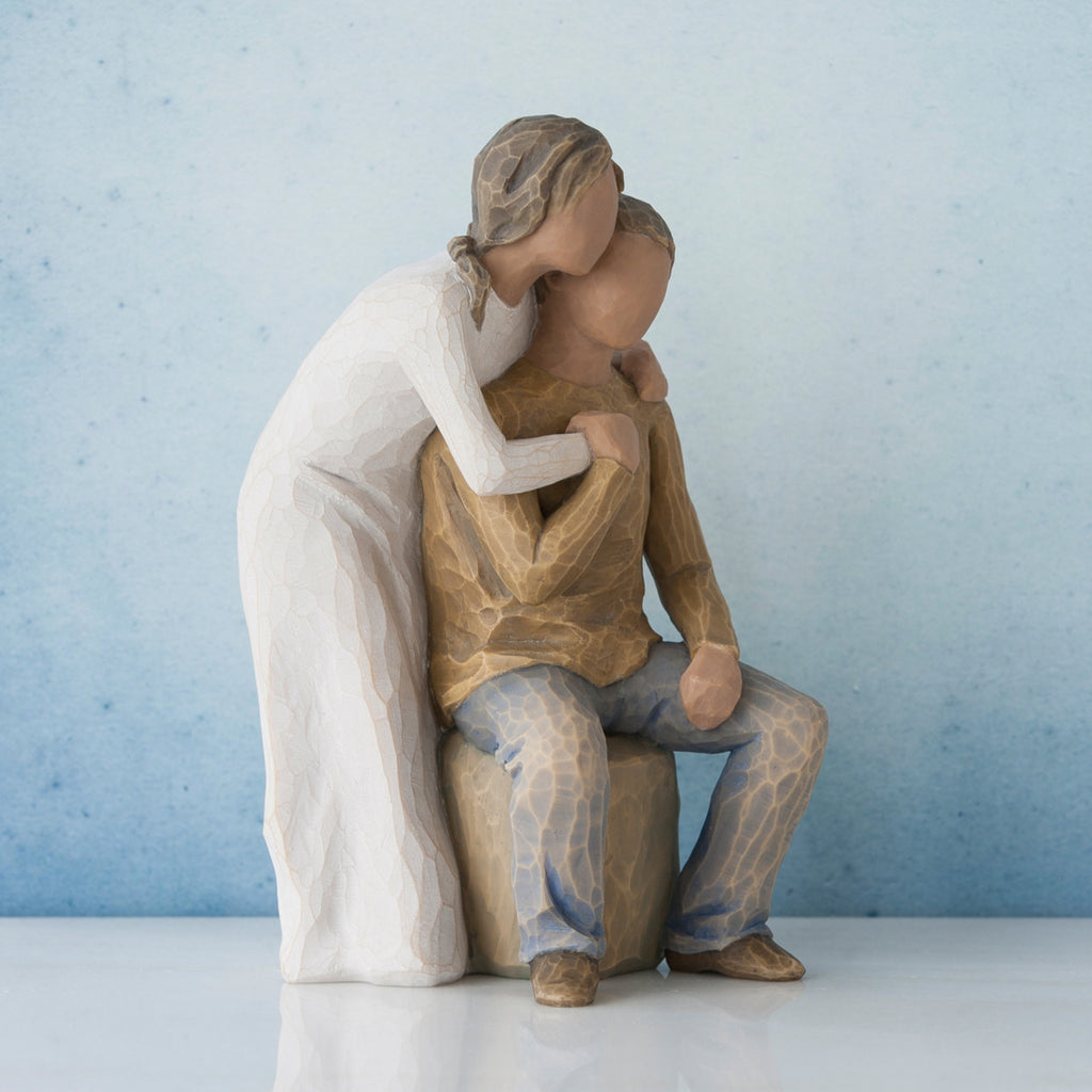 Man and woman figurine - man is sitting down with woman figurine bending down