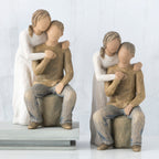 Set of two man and woman figurines - man is in brown sitting, woman is in white standing over him with arms on his shoulders