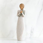 Faceless woman figurine standing facing forward wearing white dress holding star print napkin