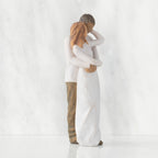 Right view of couple, standing with arms around each other. Woman has lighter skin and hair; man has darker skin and hair.