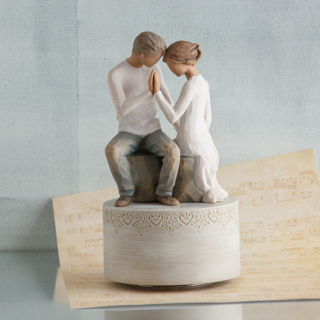 Man and woman figurines holding hands on cream raised rock pendant