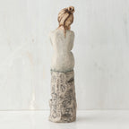 Back view of brunette girl sitting on grey rock