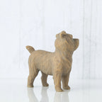 Figure of small brown dog standing on four legs, facing right