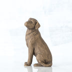 Dark brown dog figurine sitting from the side