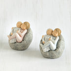 Set of two - baby figurines being held by larger sibling figurines on grey bean bags