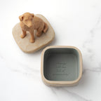 Inside: putty-colored square resin box with sentiment written on bottom inside of box. Detached lid