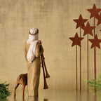 Back view of wiseman figurine in tan dress next to lamb - five red star stands to the right